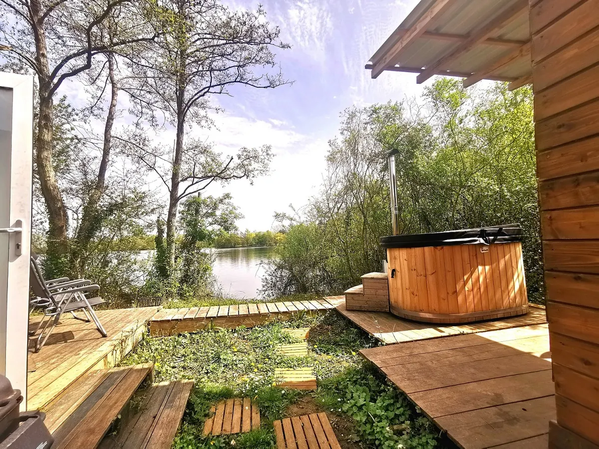 Bain nordique sur terrasse en bois avec vue sur le lac