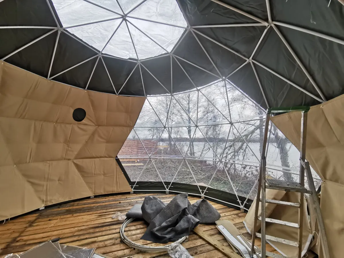 Construction de l'intérieur d'un dôme géodésique avec vue sur le lac