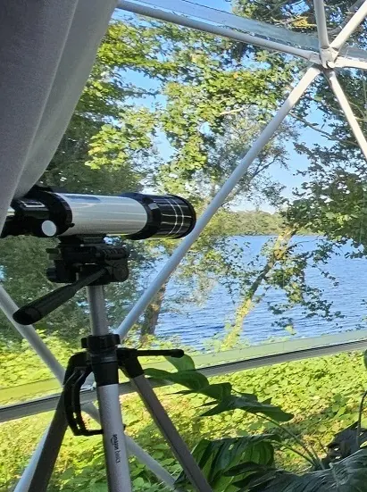 Télescope installé dans un dôme géodésique avec vue sur le lac